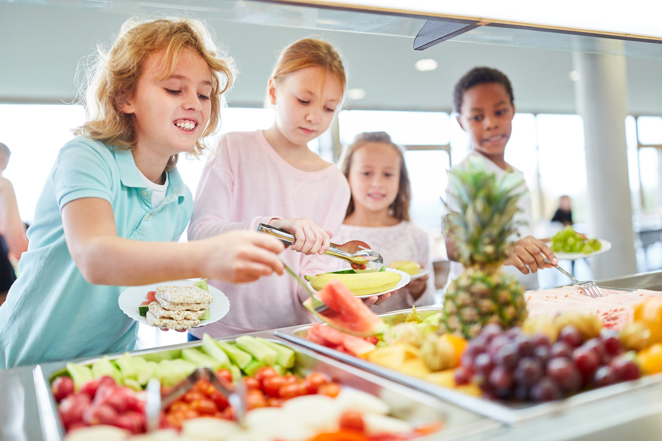 Children choosing fresh fruit at a lunch buffet